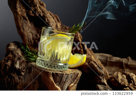 Cocktail gin and tonic with lemon slices and sprig of rosemary. 133622959