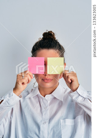 Woman covering eyes with colorful sticky notes 133623005