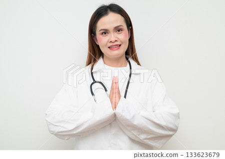 Happy Smiling Thai Healthcare Professional Doctor in White Coat Greeting with Wai Gesture Happy Smiling Thai Healthcare Professional Doctor in White Coat Greeting with Wai Gesture 133623679