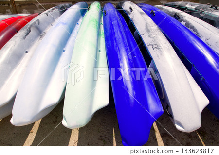 Beach colorful kayak rows lying on sand in sunny day Beach colorful kayak rows lying on sand in sunny day 133623817