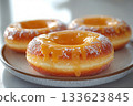 Food marketing. Glazed yellow donuts. Donuts on a ceramic  plate on a white background. Sweet topping food. 133623845