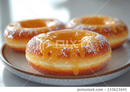 Food marketing. Glazed yellow donuts. Donuts on a ceramic  plate on a white background. Sweet topping food. 133623845