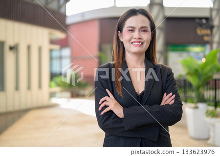 Happy Smiling Thai Business Woman Outdoors in Professional Attire with Arms Crossed Happy Smiling Thai Business Woman Outdoors in Professional Attire with Arms Crossed 133623976
