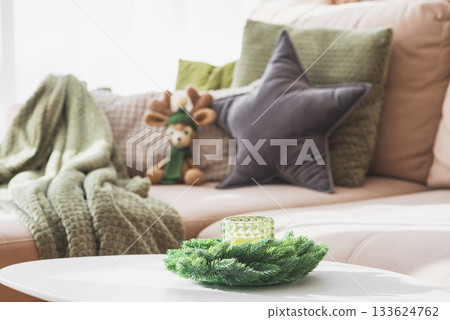 Cozy Living Room with Crocheted Reindeer Toy on Sofa and Christmas Holiday Candle Decor on Table Cozy Living Room with Crocheted Reindeer Toy on Sofa and Christmas Holiday Candle Decor on Table 133624762