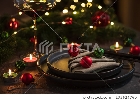 Christmas Table Setting with Tree-Shaped Napkin and Tealight Candles against Christmas lights Christmas Table Setting with Tree-Shaped Napkin and Tealight Candles against Christmas lights 133624769