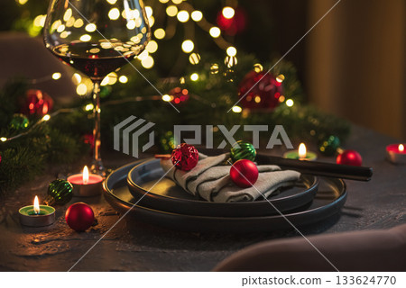 Christmas Table Setting with Tree-Shaped Napkin and Tealight Candles against Christmas lights Christmas Table Setting with Tree-Shaped Napkin and Tealight Candles against Christmas lights 133624770