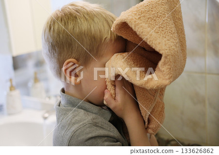 Young boy drying face with soft towel in bathroom 133626862
