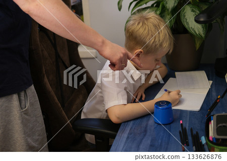 Parent pointing at unhappy child doing homework studying education 133626876