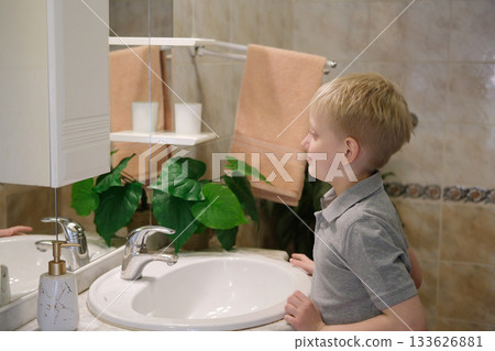 Young boy looking at real reflection in bathroom mirror Young boy looking at real reflection in bathroom mirror 133626881
