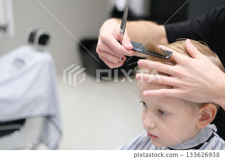 Child receiving haircut in barbershop, fresh style Child receiving haircut in barbershop, fresh style 133626938