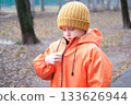 Child zipping rain jacket in park outdoors 133626944