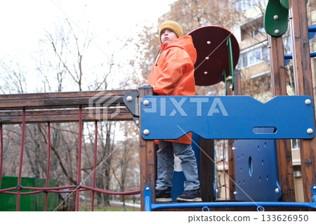 Young boy playing on urban playground in autumn 133626950