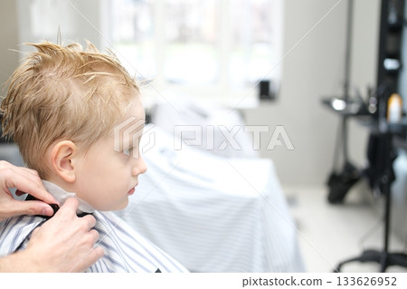 Young boy receiving haircut at barbershop Young boy receiving haircut at barbershop 133626952