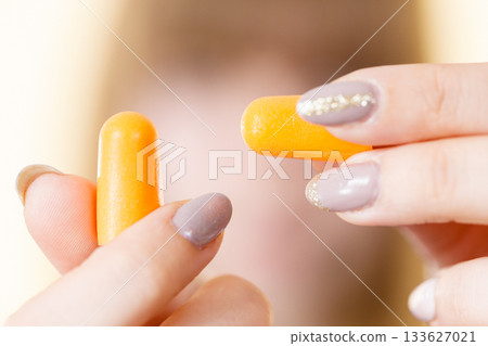 Woman holding protective earplugs Woman holding protective earplugs 133627021