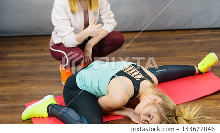 Woman in sportswear doing workout with trainer Woman in sportswear doing workout with trainer 133627046