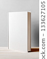 Blank hardcover book standing on wooden table against a soft gray background, ideal for mock up designs and creative projects with copy space 133627105