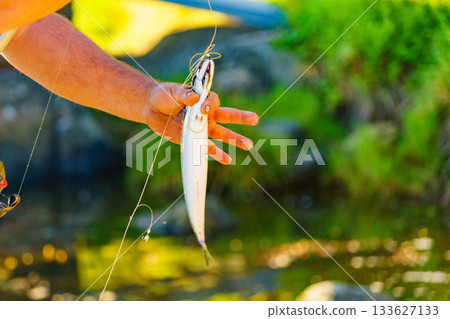 Fisherman holds fish in hand Fisherman holds fish in hand 133627133