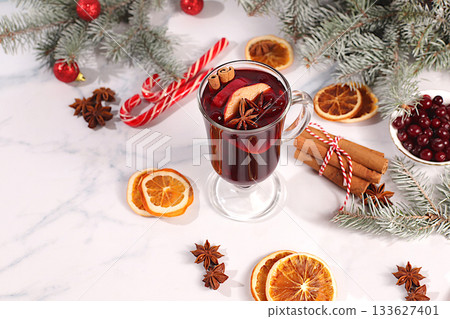Mulled wine with spices, star anise, cranberry, orange, apple and cinnamon, a warming winter drink in the cold season, a strong alcoholic or non-alcoholic cocktail on the festive table, a 133627401