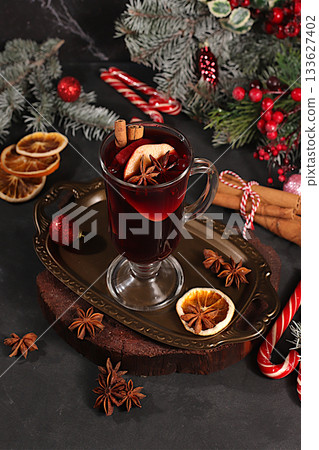 Mulled wine with spices, star anise, cranberry, orange, apple and cinnamon, a warming winter drink in the cold season, a strong alcoholic or non-alcoholic cocktail on the festive table, a Mulled wine with spices, star anise, cranberry, orange, apple and cinnamon, a warming winter drink in the cold season, a strong alcoholic or non-alcoholic cocktail on the festive table, a 133627402