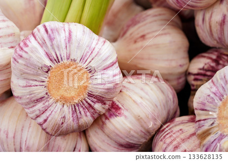 Packs of fresh garlic with purple stripes on display at local food market, closeup detail 133628135