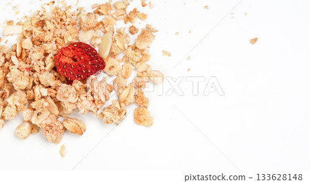 Muesli flakes with one dried strawberry, closeup photo isolated on white background space for text right side 133628148