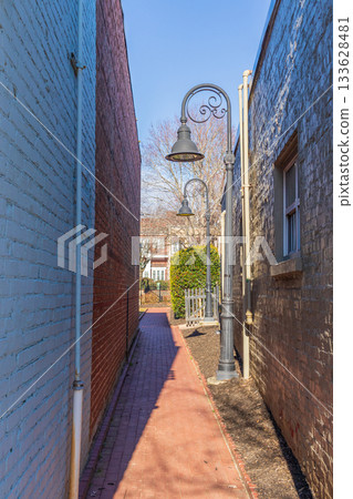 A narrow alleyway with a brick wall on either side A narrow alleyway with a brick wall on either side 133628481