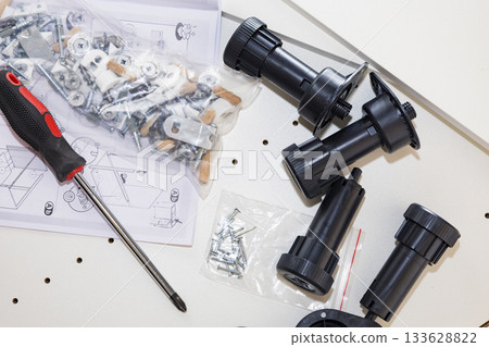 Closeup view of hardware assembly set in workshop environment, Detailed image showcasing electronics parts and tools arranged on workspace with natural lighting Closeup view of hardware assembly set in workshop environment, Detailed image showcasing electronics parts and tools arranged on workspace with natural lighting 133628822