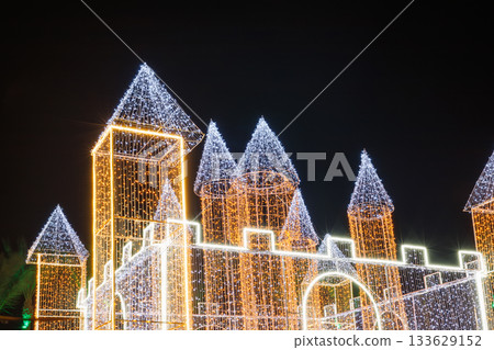 Illuminated castle structure with colorful lights at night 133629152