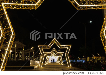 Illuminated star-shaped arches in night scene Illuminated star-shaped arches in night scene 133629168