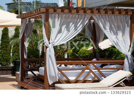 White beach canopy. Luxury beach tents with white curtains at the resort. Summer vacation concept. Beach bungalows in Sochi, Mandarin Beach, Adler, Russia 133629323