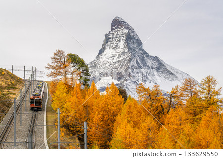 Gornergrat Red Railway Train, Matterhorn Mountain and Golden Larches in Autumn. Switzerland Gornergrat Red Railway Train, Matterhorn Mountain and Golden Larches in Autumn. Switzerland 133629550