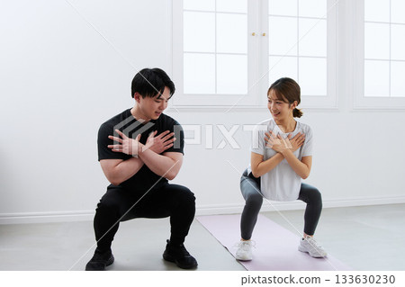 Young woman receiving training from a personal trainer 133630230