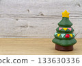 A miniature Christmas tree with a star on a wood background 133630336