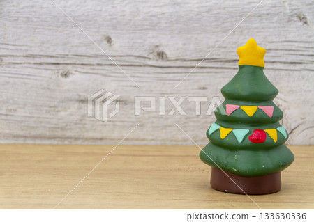 A miniature Christmas tree with a star on a wood background A miniature Christmas tree with a star on a wood background 133630336