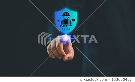 Businessman pointing at a glowing digital shield icon showing Safety First, symbolizing workplace safety, cyber protection, risk management and secure technology. Businessman pointing at a glowing digital shield icon showing Safety First, symbolizing workplace safety, cyber protection, risk management and secure technology. 133630492