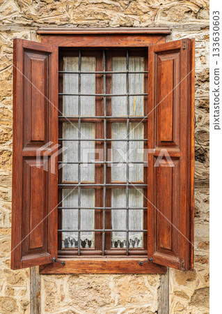 Rustic wooden window with iron bars on stone wall Rustic wooden window with iron bars on stone wall 133630603