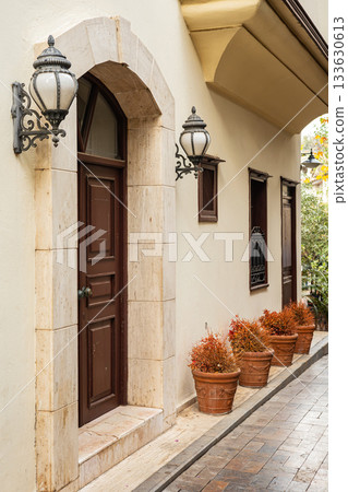 Charming mediterranean alley with wooden door and decorative lanterns Charming mediterranean alley with wooden door and decorative lanterns 133630613