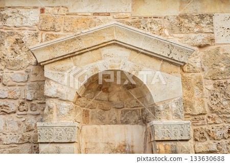 Weathered stone arch on rustic wall with intricate patterns Weathered stone arch on rustic wall with intricate patterns 133630688