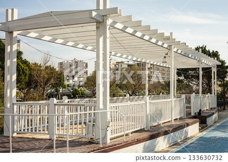Modern white pergola in urban park with cityscape background 133630732