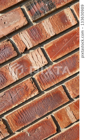 Close-Up Of Red Brick Wall Texture With Weathered Surfaces and Rugged Character 133630989