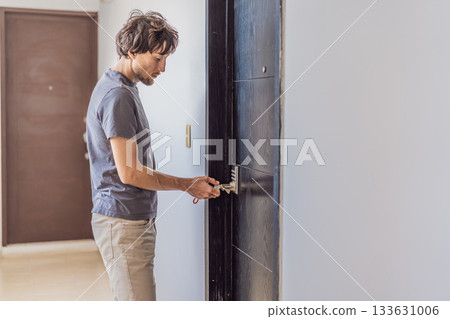 Man locking the apartment door with a key, ensuring home security and safety. Concept of personal safety, domestic life, responsibility, and modern lifestyle at home 133631006