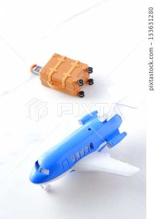 Airplane and suitcase - Image of a plane waiting to take off and a suitcase (carry-on case) departing for a trip Airplane and suitcase - Image of a plane waiting to take off and a suitcase (carry-on case) departing for a trip 133631280