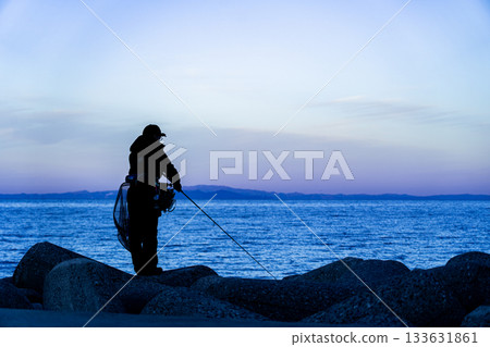 黎明時分，漁夫的身影漂浮在蔚藍的海面上 133631861
