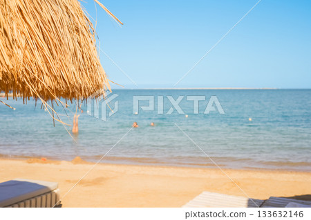 Three people swimming near sandy beach umbrella on blurred background Three people swimming near sandy beach umbrella on blurred background 133632146