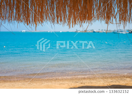 Straw umbrella overlooking the turquoise Red Sea in Egypt Straw umbrella overlooking the turquoise Red Sea in Egypt 133632152
