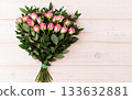 Pink rose bouquet greenery natural light romantic floral arrangement on wooden board, gentle bright mood, high resolution natural look 133632881