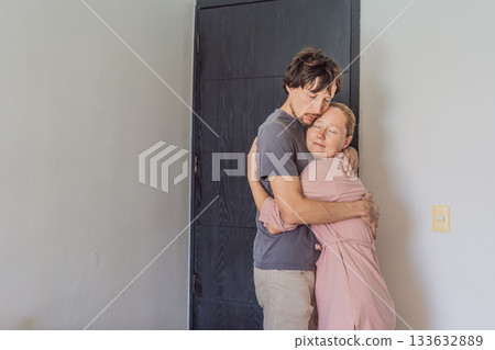 Man and woman hugging goodbye at the front door, sharing a tender emotional moment before parting ways. Concept of love, connection, farewell, relationships, and everyday intimate human emotions Man and woman hugging goodbye at the front door, sharing a tender emotional moment before parting ways. Concept of love, connection, farewell, relationships, and everyday intimate human emotions 133632889