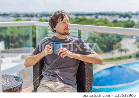 Man drinking coffee on the balcony in the morning. Concept of relaxation, lifestyle, routine, peaceful moments, and enjoying a warm drink outdoors at home Man drinking coffee on the balcony in the morning. Concept of relaxation, lifestyle, routine, peaceful moments, and enjoying a warm drink outdoors at home 133632900