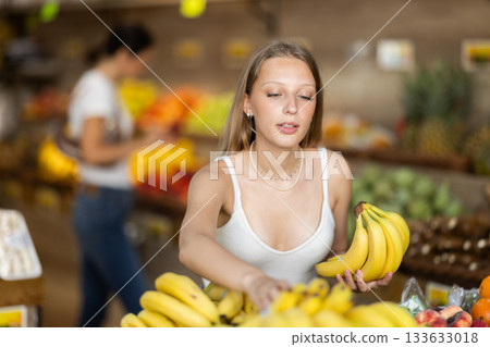 Blonde woman near the banana counter in the store Blonde woman near the banana counter in the store 133633018