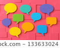A vibrant collage of multicolored speech bubbles scattered across a bright pink textured background, symbolizing dialogue, ideas, and social interaction in creative communication collaboration context 133633024